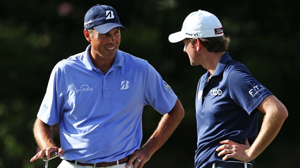 Matt Kuchar (L) talks to Webb Simpson on the 15th green