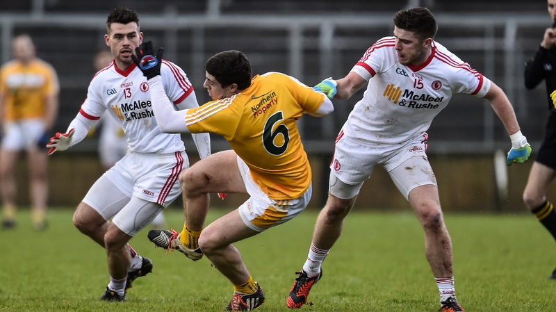 Antrim's Declan Lynch takes a fall under pressure from Tyrone's Darren McCurry and Connor McAliskey