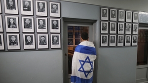 One of the Israeli visitors looks at the images of some of the camp's prisoners