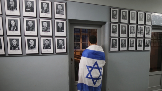 One of the Israeli visitors looks at the images of some of the camp's prisoners