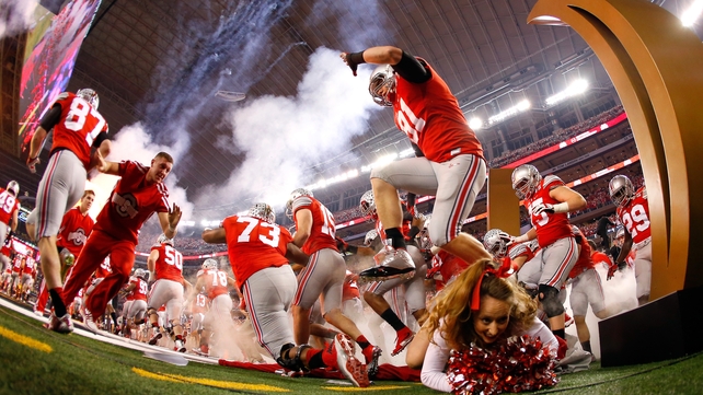 An Ohio State Buckeyes cheerleader falls as the team run out before the College Football National Championship game in Arlington, Texas