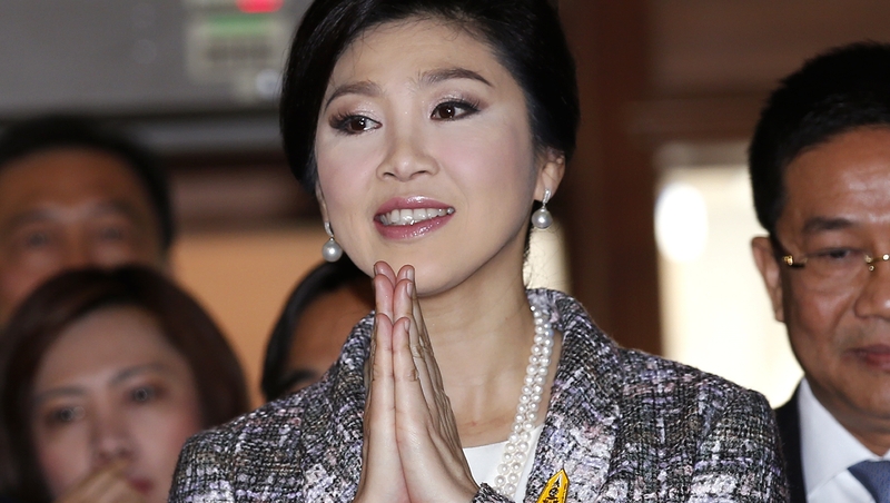 Former Thai prime minister Yingluck Shinawatra greets in the traditional way as she arrives to answer questions to the National Legislative Assembly during impeachment proceedings against her