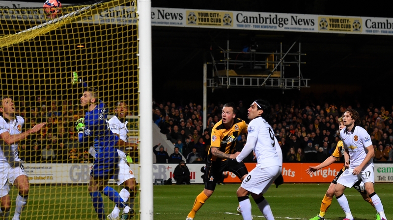 Josh Coulson of Cambridge United heads over in what was the game's best chance