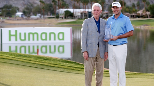 Bill Haas receives his trophy from former US president Bill Clinton