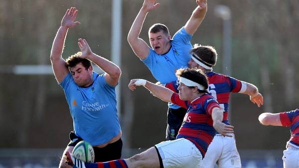 UCD's Liam Hyland and Ross Moloney charge down Sam Cronin of Clontarf