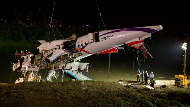 The fuselage is lifted onto the river bank
