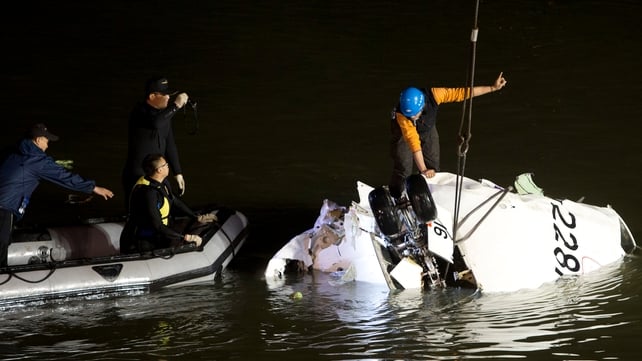 A worker attaches cables to the fuselage