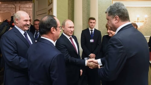 Russian President Vladimir Putin (C) shakes hands with Ukrainian President Petro Poroshenko