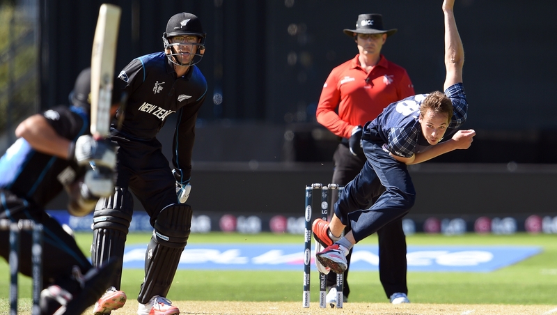 Scotland bowler Josh Davey (R) sends down a delivery to New Zealand batsman Adam Milne