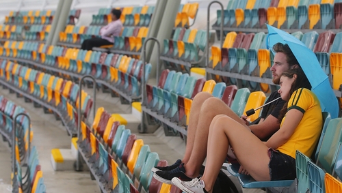 Fans wait for the rain to clear at The Gabba in Brisbane for the Australia v Bangladesh match - it didn't and the match was abandoned