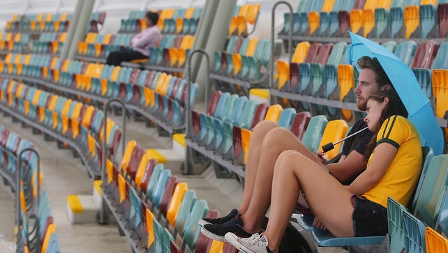 Fans wait for the rain to clear during the Cricket World cup match between Australia and Bangladesh at The Gabba, in Brisbane, Australia