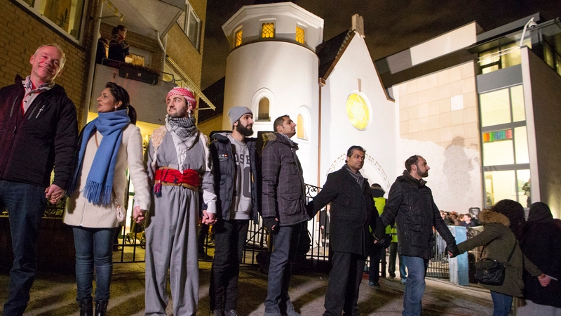 Jews and Muslims hold hands as they join in a ring of solidarity around the synagogue in Oslo, Norway