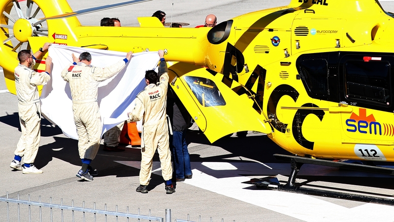Fernando Alonso is transferred from the medical centre to the helicopter after crashing at the Circuit de Catalunya