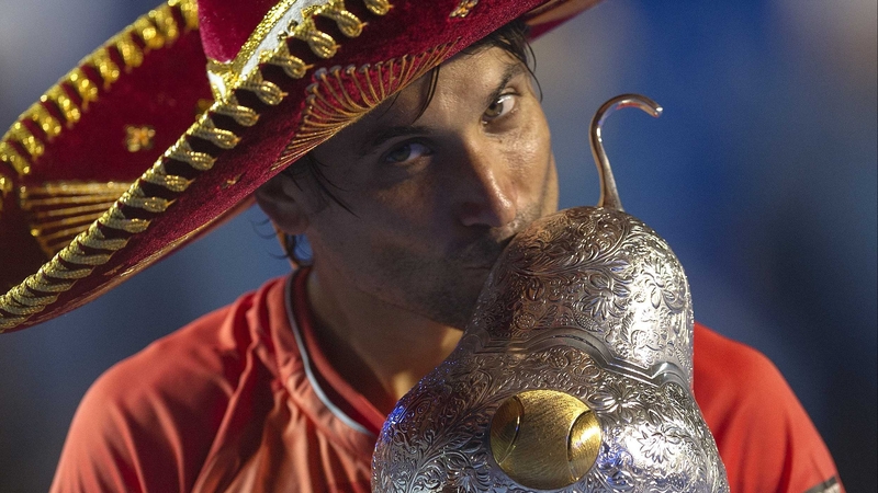 David Ferrer dons a sombrero as he cradles the Mexican Open trophy at the Fairmont Acapulco Princess resort