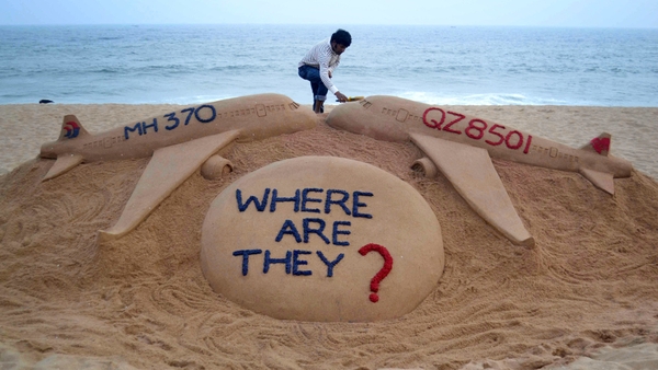 Indian sand artist Sudarsan Pattnaik portrays two missing aircraft, Air Asia QZ8501 and Malayasia Airlines MH370 on Golden Sea Beach at Puri