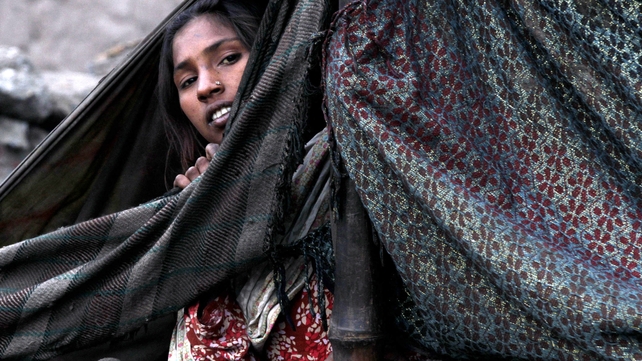 A gypsy woman looks on from her temporary shelter on the outskirts of Lahore, Pakistan