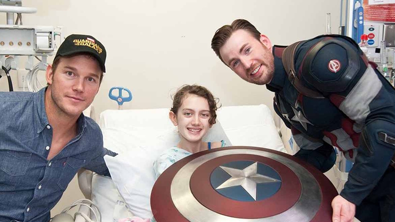 Chris Pratt and Chris Evans with a patient at Seattle Children's Hospital who looks delighted to see them