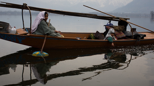 A fisherwoman rows her boat on Dal lake in Kashmir, India