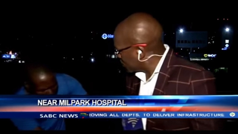 The video shows two men pacing around reporter Vuyo Mvoko while he speaks to the camera, before a scuffle ensues