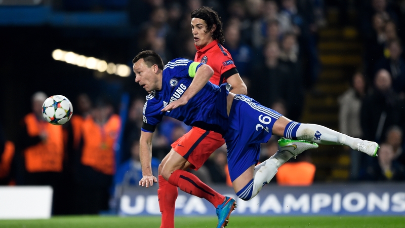 John Terry of Chelsea heads the ball clear before it can reach Edinson Cavani of PSG