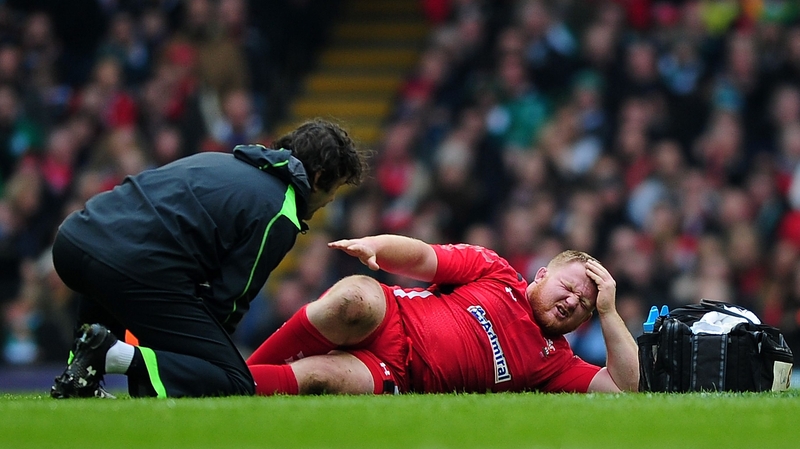 Samson Lee of Wales receives attention to a leg injury sustained against Ireland