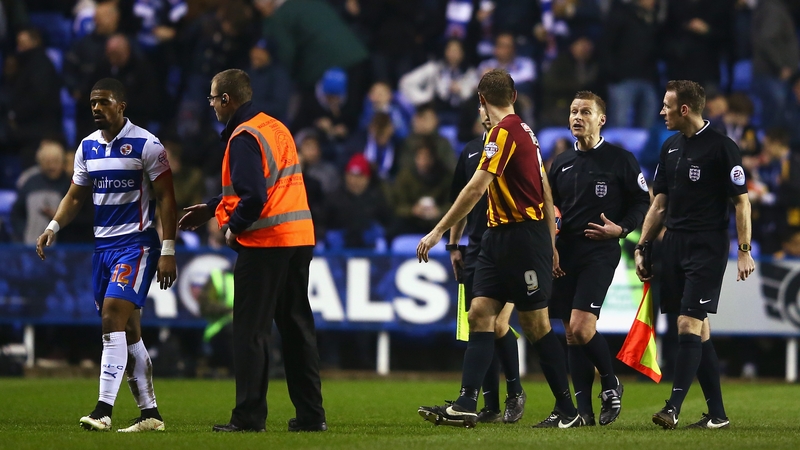 Garath McCleary of Reading walks off for half-time as James Hanson of Bradford City talks to referee Mike Jones