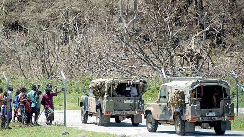 Residents of the area watch an Australian Army relief convoy as it arrives on the Vanuatu island of Tanna