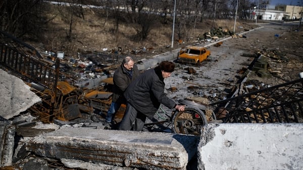 Men push a cart over a destroyed bridge near Donetsk airport in eastern Ukraine