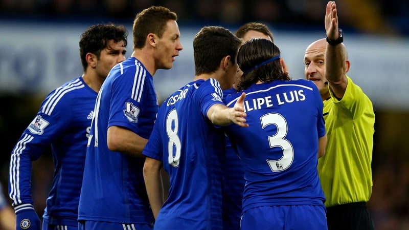 Players from Chelsea surround a referee as they appeal a decision