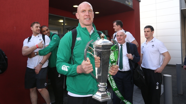 Paul O'Connell brings the Six Nations trophy back home through Dublin Airport, while Simon Zebo gives Jamie Heaslip a hug