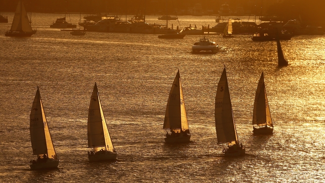 Yachts sail in a twilight regatta on Sydney Harbour