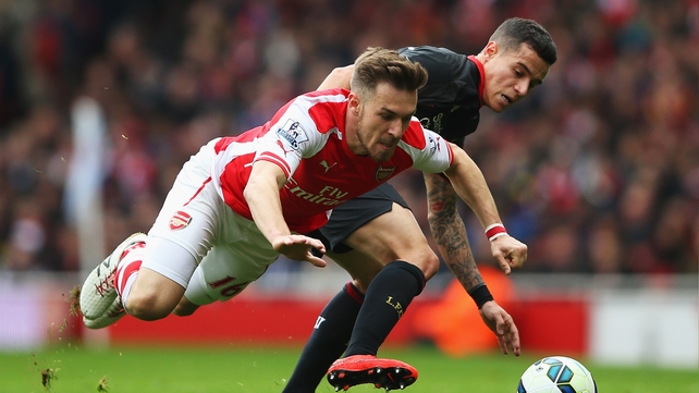 Aaron Ramsey of Arsenal battles for the ball with Philippe Coutinho of Liverpool during the Barclays Premier League match between Arsenal and Liverpool at Emirates Stadium