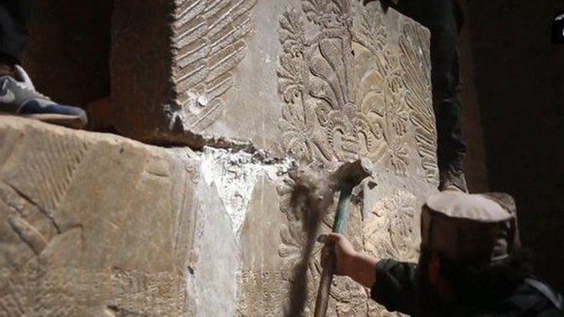 So called IS militants are seen hacking away at the statues with sledgehammers