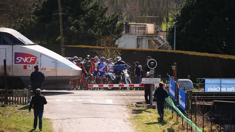 A number of riders in the peloton crossed the railway tracks after the safety barrier has descended