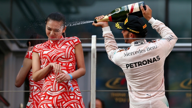 Lewis Hamilton sprays champagne in the face of a hostess after winning the Shanghai Grand Prix... the big eejit