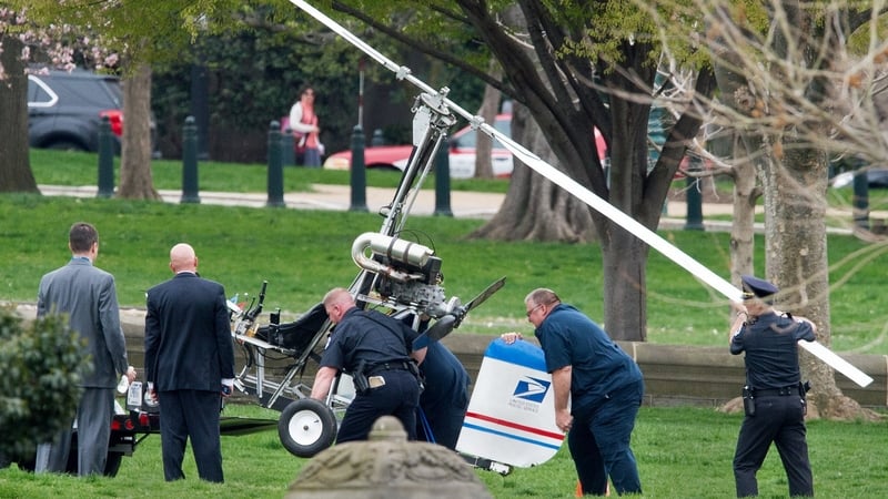 Capitol Hill police officers and other officials lift the gyrocopter following the incident
