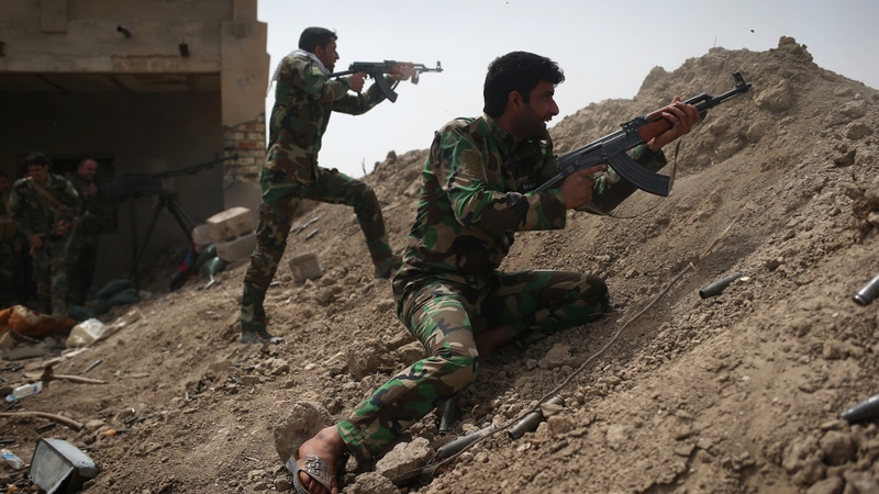 Volunteers from the Shia Badr Brigade militia fire on IS fighters on the frontline in Ebrahim Ben Ali, Anbar