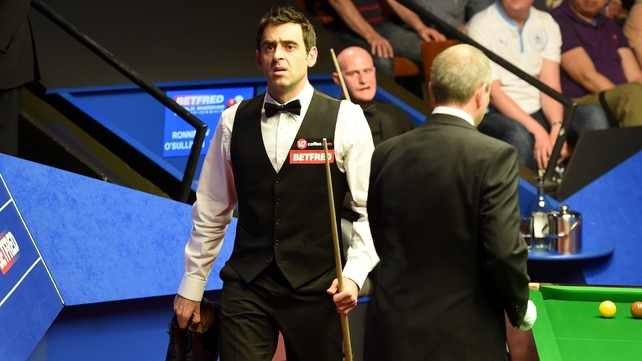 Ronnie O'Sullivan talks with referee Brendan Moore about shoes after he played in his socks against Craig Steadman, during the Betfred World Championships at the Crucible Theatre, Sheffield on Tuesday