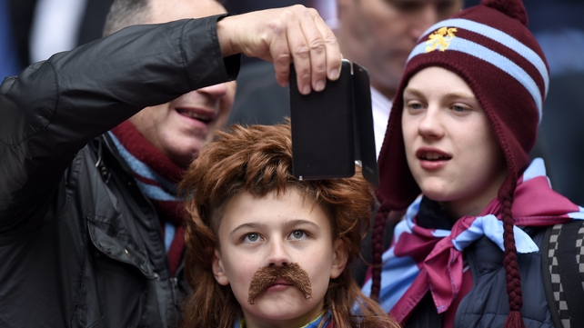Aston Villa fans pose for a photograph in the stands during the FA Cup Semi Final match against Liverpoolat Wembley Stadium