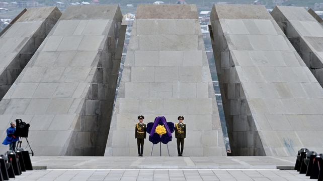 A camerman looks on as soldiers stand guard in front of the Tsitsernakaberd Memorial n