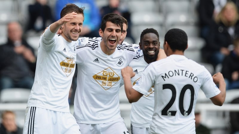 Swansea players mob Gylfi Sigurosson after he put them ahead
