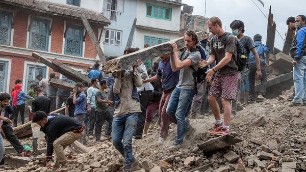 Bystanders and rescuers alike remove rubble