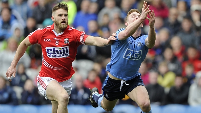 Dublin’s Ciaran Kilkenny scores a point despite the attentions of Cork's Eoin Cadogan in the Allianz Football League Division 1 final...