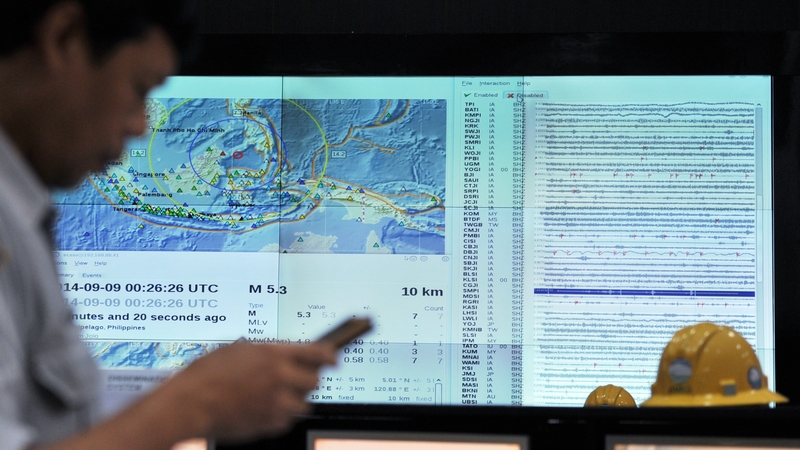 An Indonesian official checks his phone for an SMS earthquake and tsunami warning alert during an Indian Ocean-wide tsunami exercise