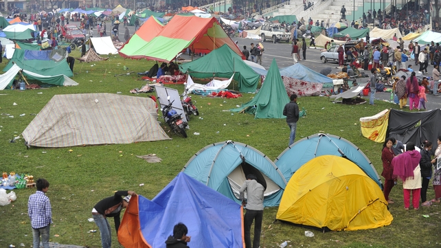 People set up tents on open ground at an army centre in Kathmandu