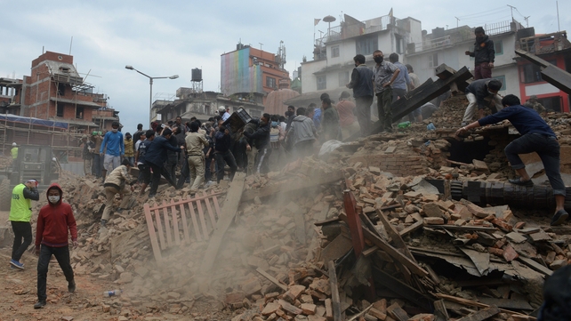People work to clear rubble in Kathmandu's historic Durbar Square in the aftermath of the quake