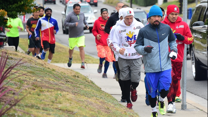 Manny Pacquiao is joined by supporters for his morning jog along a city street to a park in Los Angeles