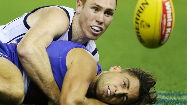 Tom Lynch of the Crows tackles Luke Dahlhaus of the Bulldogs during their round four AFL match at Etihad Stadium