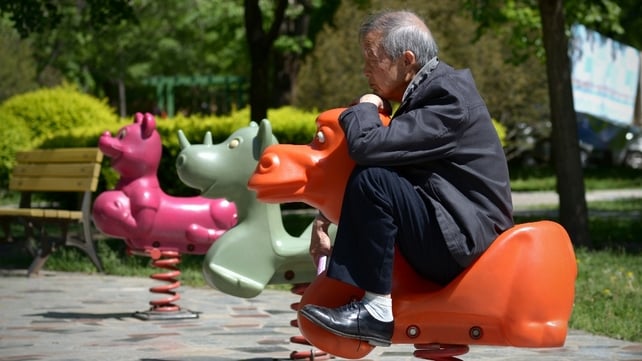 An elderly man relaxes on rocking horse in Beijing, China