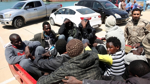 Migrants are held in a pick up truck at the Port of Tripoli after the Libyan coastguard intercepted their boat